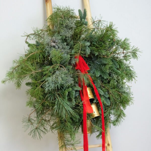 Spygliuočių šakų vainikas su raudona juosta ir varpeliais